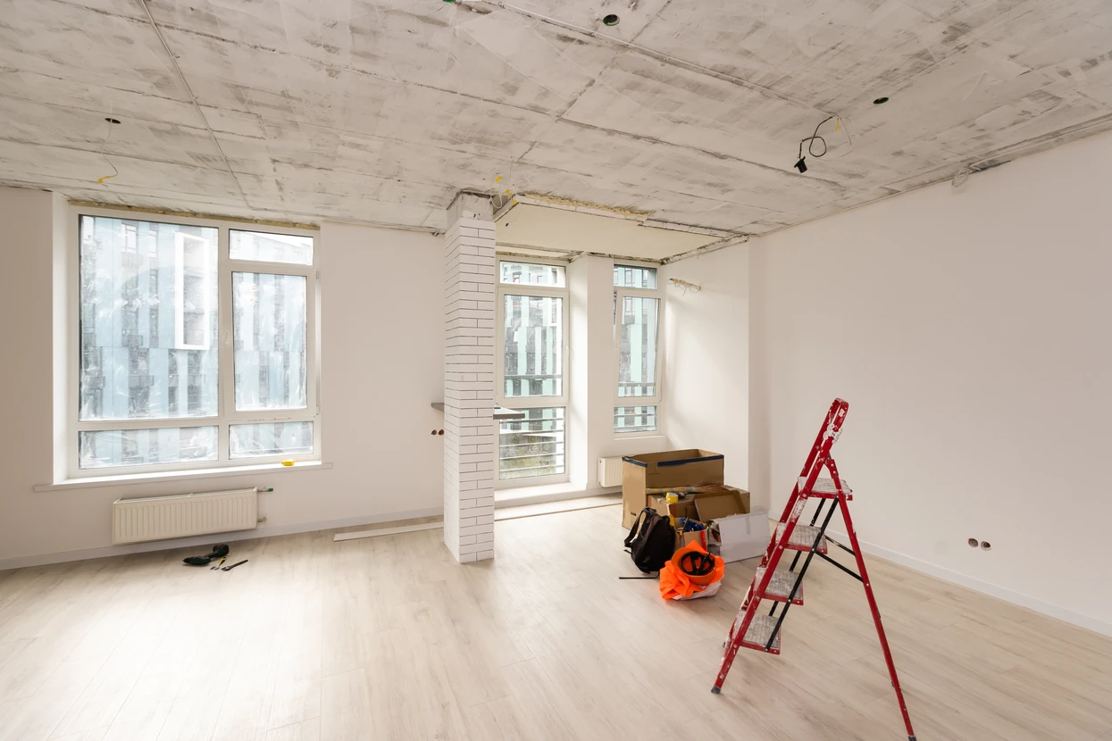 Avant et après de l'homme utilisant un rouleau de peinture pour révéler la nouvelle salle remodelée avec de la peinture verte fraîche, plafond caissonné et de Nouveaux sols