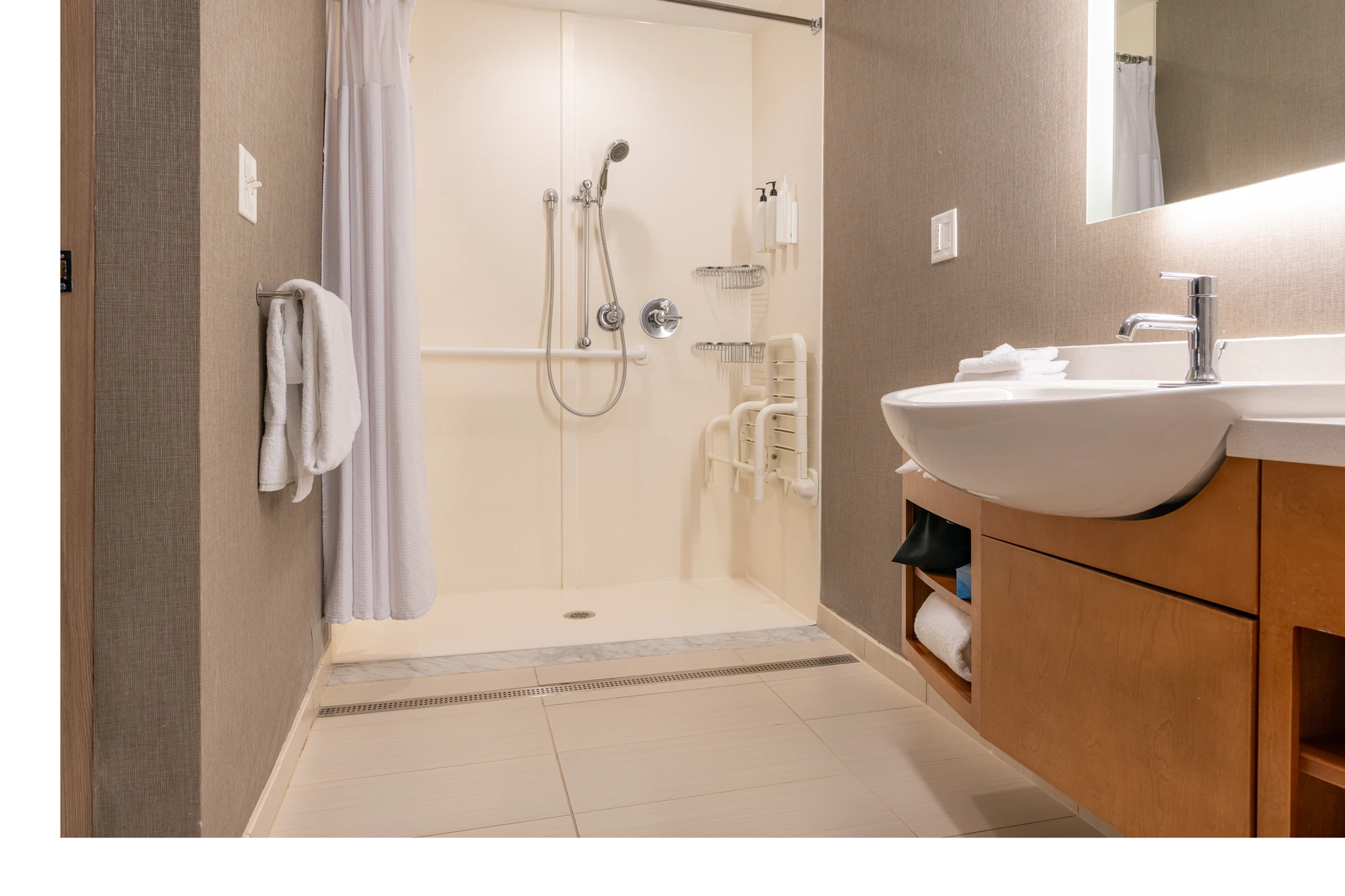 Salle de bain adaptée avec baignoire blanche équipée de barres d'appui murales en acier inoxydable